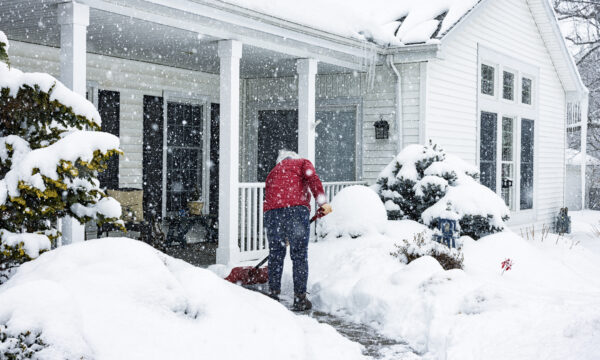 person shoveling snow outside their house