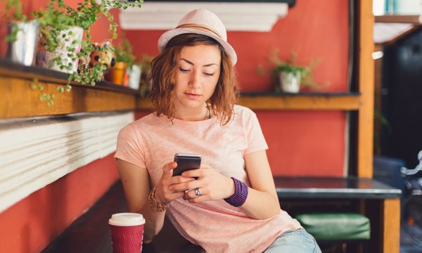 Young woman using cell phone in coffee shop
