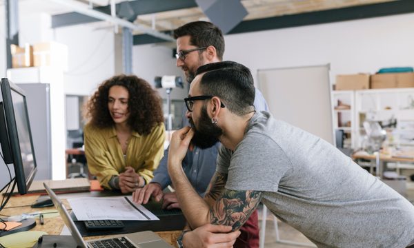 Small group of co-workers working together in a startup business office space.