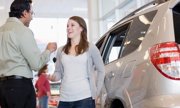 Car dealer handing woman keys