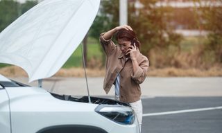 Person looking at car with open hood.