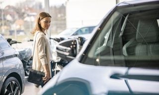 Woman browsing vehicles at a car dealership