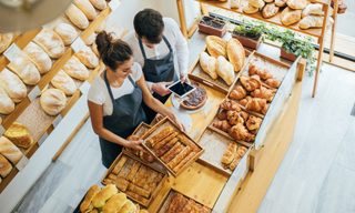 Two employees using a tablet at a bakery.